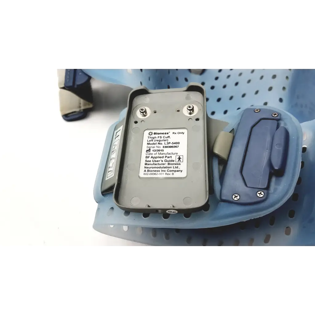 Gray rectangular bioness l300 plus thigh cloth electrodes with blue plastic components and metallic screws