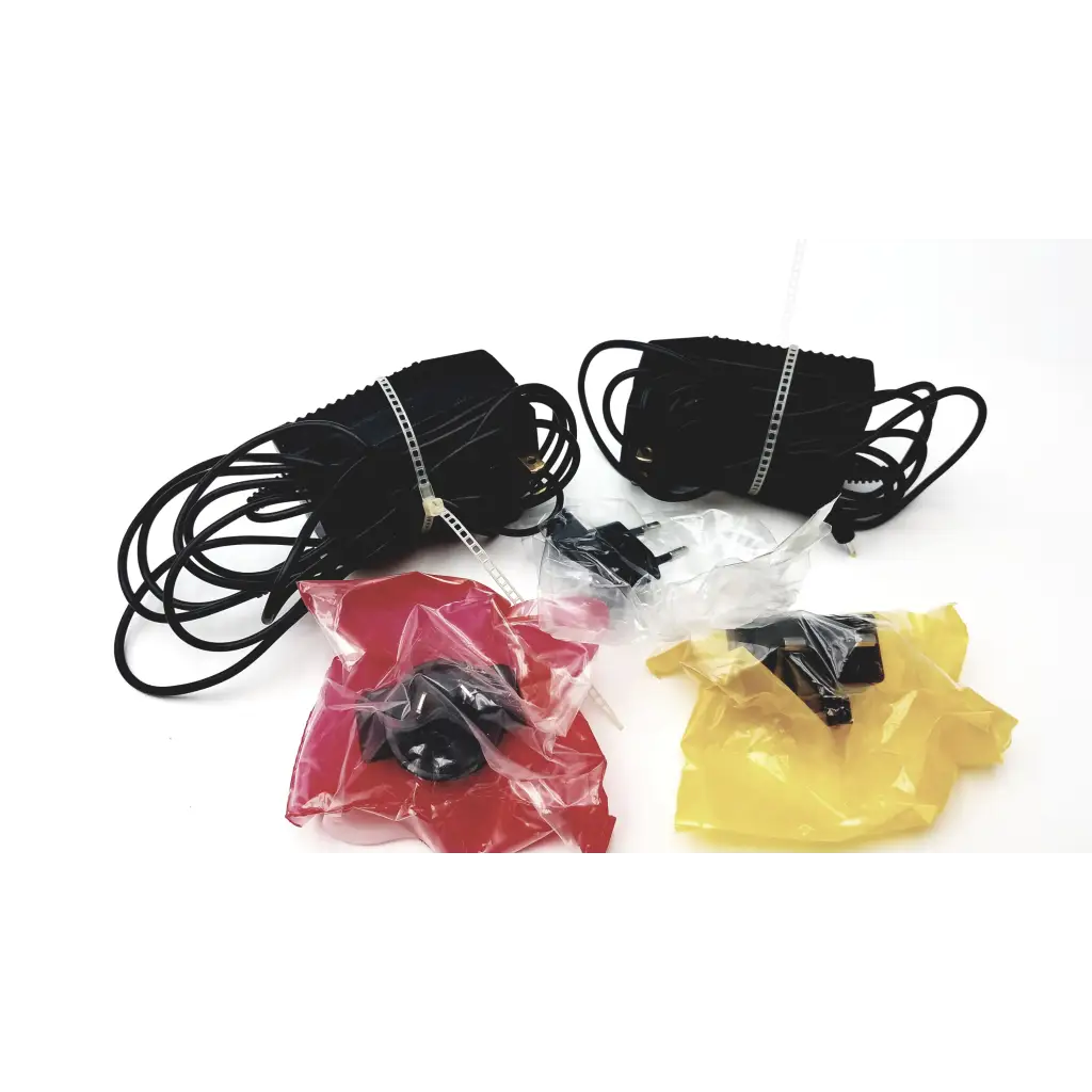 Two black power adapters with coiled cords for bioness l300 plus thigh cloth electrodes device components
