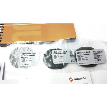 Bioness l300 plus thigh cloth electrodes showing black and silver circular adhesive foot sensor pads in clear plastic packaging