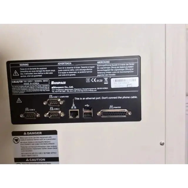 Black rectangular label on the back of biospace inbody 720 body composition analyzer showing ports for com 1 com 2 ethernet usb and printer