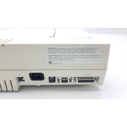 Back side of beige burdick e350i electrocardiograph showing warning label ac power inlet ethernet and two db-25 ports