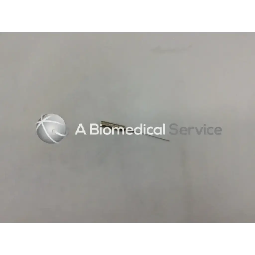 A metallic byron col-mini ii-s 070628-08 infiltration cannula style needle with slender shaft and pointed tip on plain surface