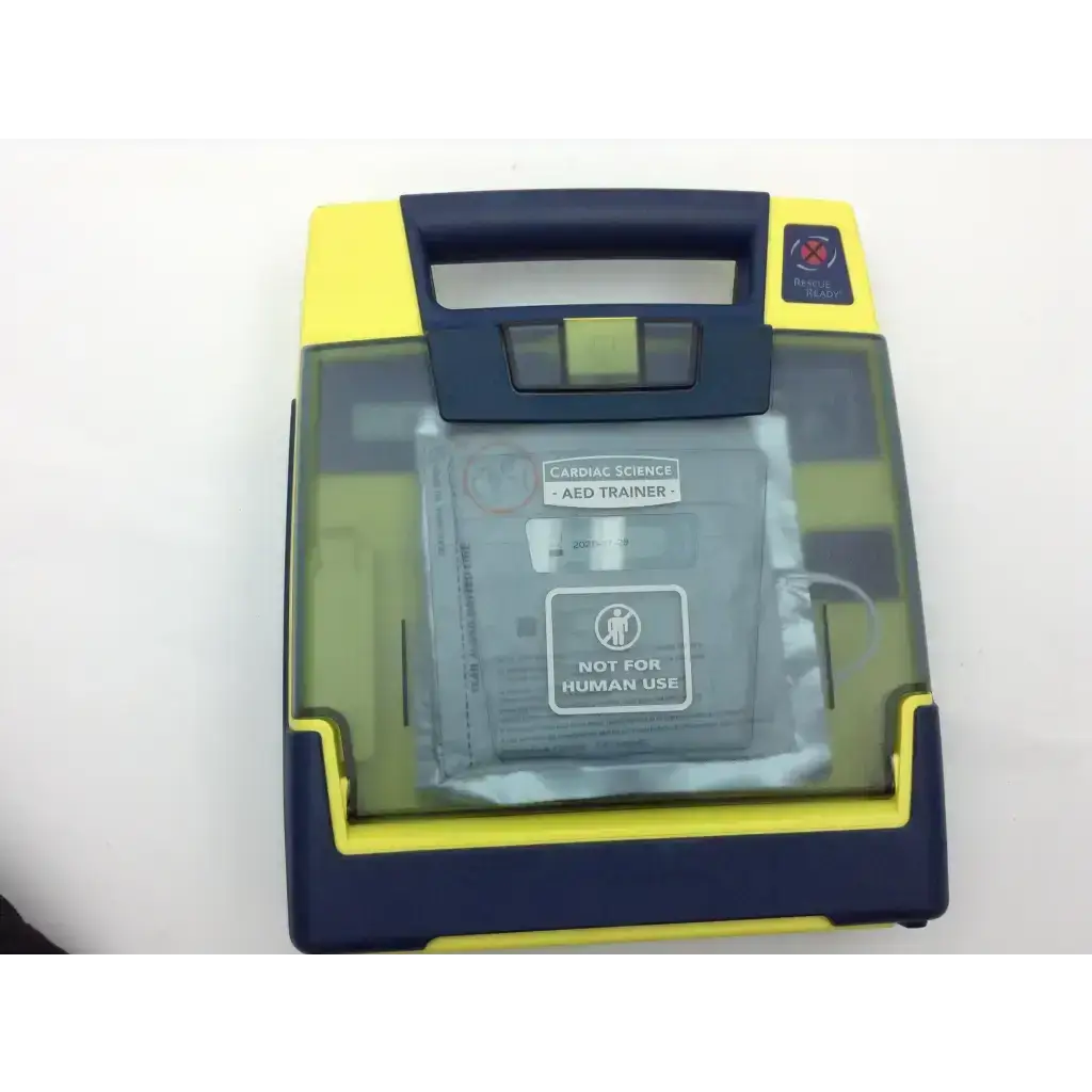 Yellow and navy blue cardiac science aed trainer with transparent front panel showing internal components for training use