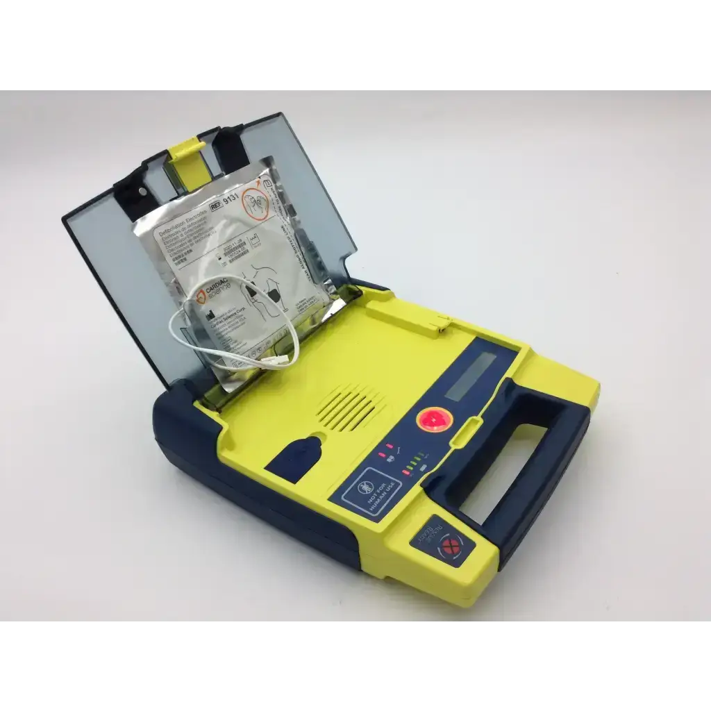 Yellow and navy blue cardiac science aed trainer with clear lid showing internal pads and included case for training use