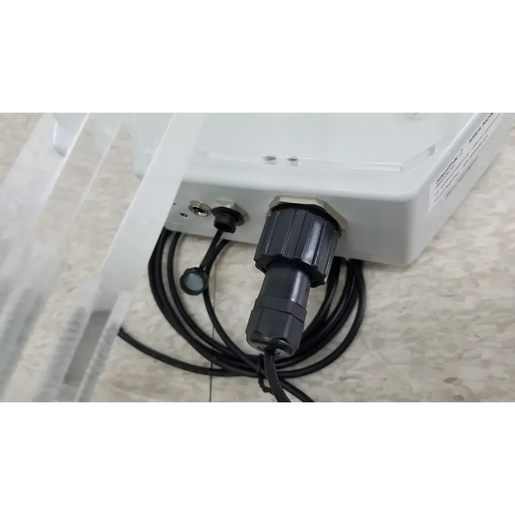 Black industrial-grade connector with coiled cable attached to chemdaq steri-trac 2 peracetic acid monitor with acrylic stand