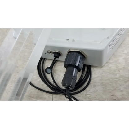 Black industrial-grade connector with coiled cable attached to chemdaq steri-trac 2 peracetic acid monitor with acrylic stand