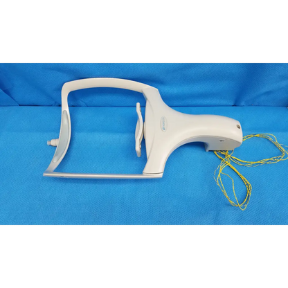 White plastic dental handpiece with yellow cord alongside chinrest forehead rest assembly for trc-nw6s retinal camera