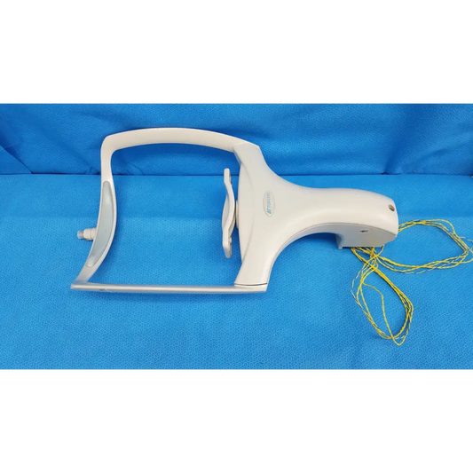 White plastic dental handpiece with yellow cord alongside chinrest forehead rest assembly for trc-nw6s retinal camera