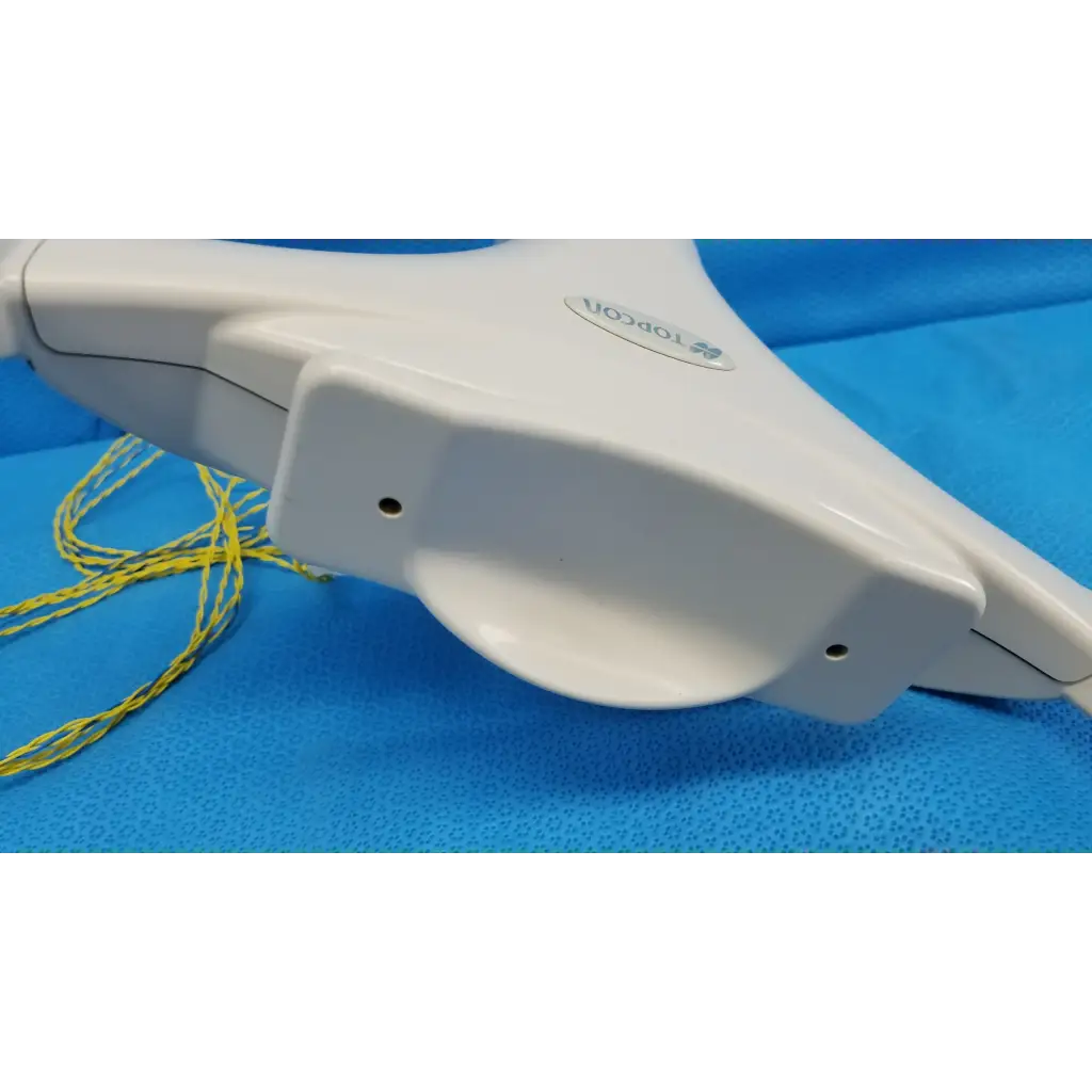 White plastic topcon surgical retractor with yellow sutures near chinrest forehead rest assembly for trc-nw6s camera