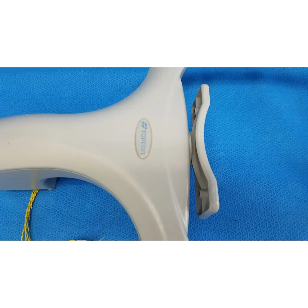 White plastic tormon handheld device with curved handle and gray clip for trc-nw6s chinrest forehead rest assembly