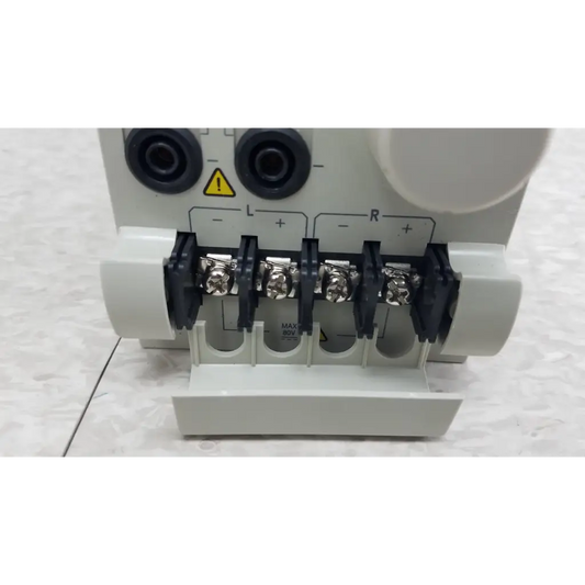 White plastic electrical terminal block with black insulated screws and silver connectors on chroma 63107 load module