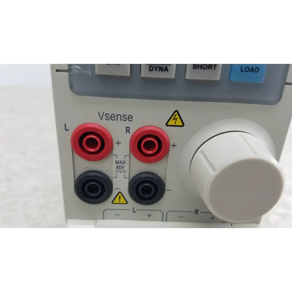 White lab power supply with red and black banana jacks l r large white voltage knob and safety warnings on chroma 63107 electronic load module