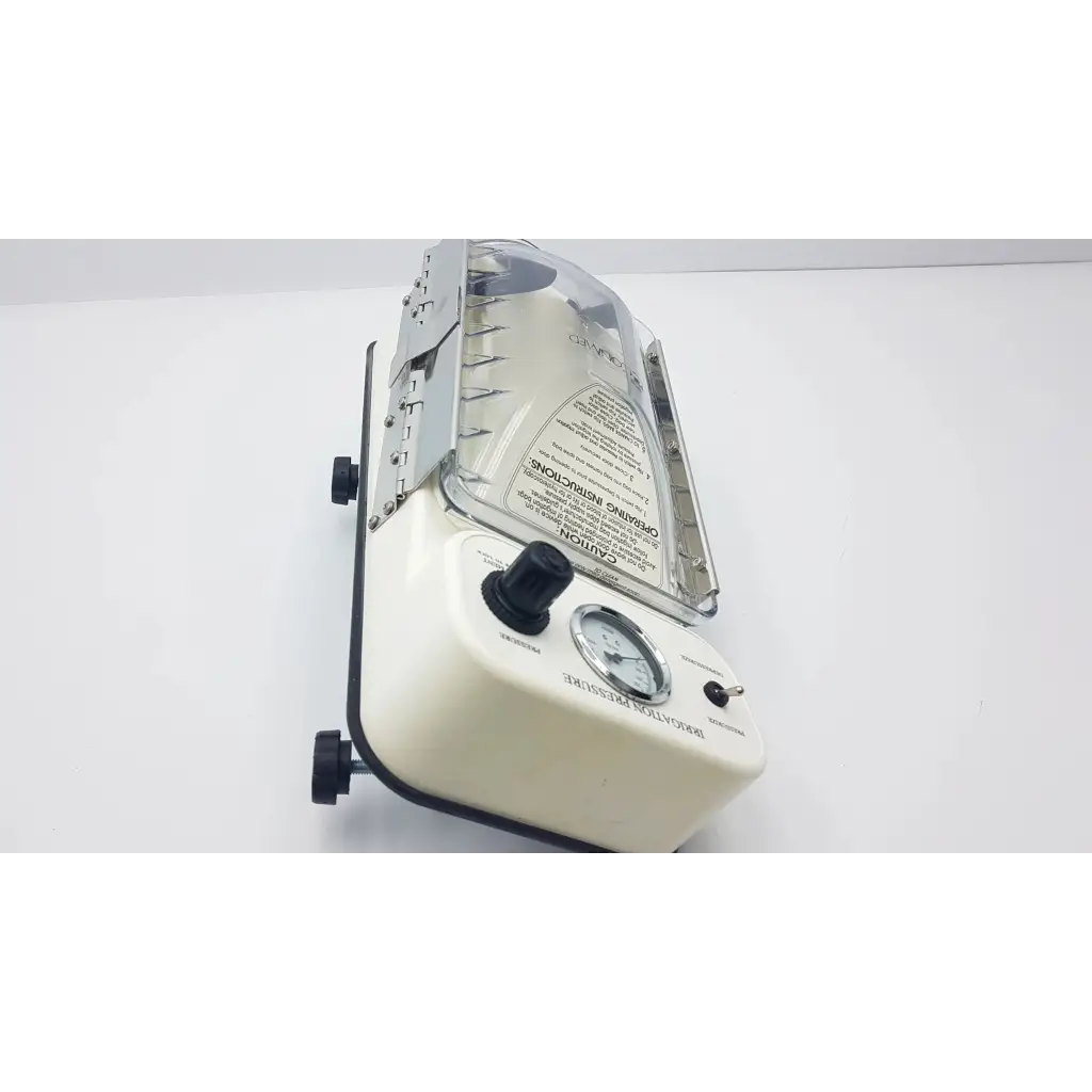Cream-colored conmed irrigation pressure system with transparent acrylic cover and black knobs for dental lab use