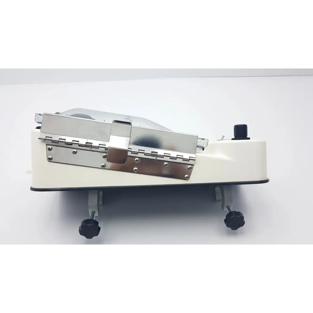 Cream-colored conmed irrigation pressure system meat slicer with stainless steel blade and black adjustable feet