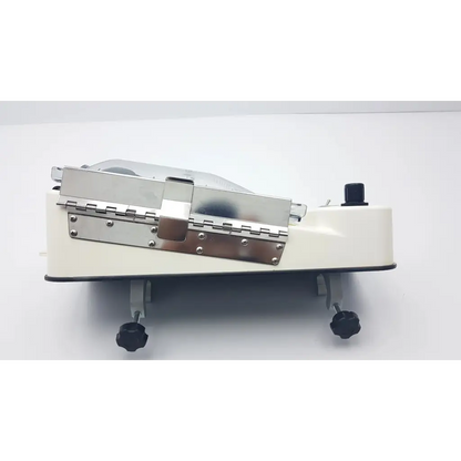 Cream-colored conmed irrigation pressure system meat slicer with stainless steel blade and black adjustable feet