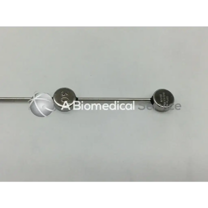A sleek metallic cook urological gyn surgical tool needle with two engraved circular end caps for obgyn use