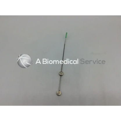 Silver-colored cook urological gyn surgical tool with slender shaft and two circular metallic discs for obgyn use