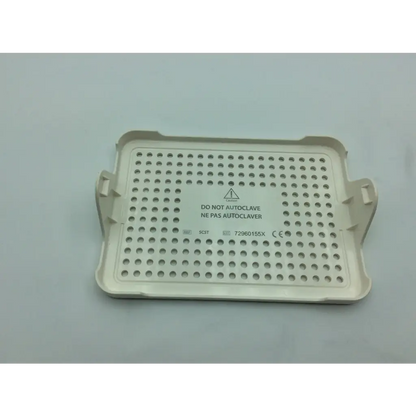 Beige plastic covidien surgical sonicision case tray with grid of circular holes and side handles for instrument storage