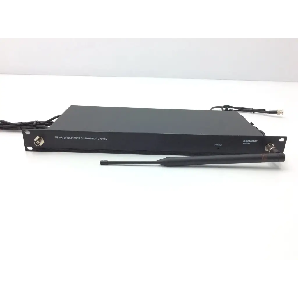 Black shure uap antenna power distribution system with matching black external antenna beside crestron cp2e professional media control processor