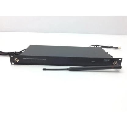 Black shure uap antenna power distribution system with matching black external antenna beside crestron cp2e professional media control processor