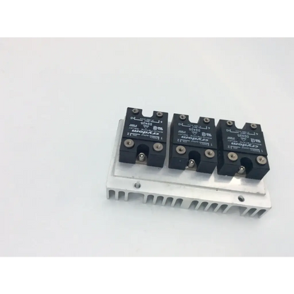 Three black crydom d1202 solid state relay modules mounted on a silver aluminum heatsink for power control