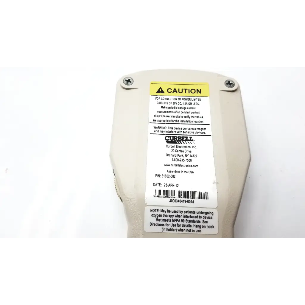 Off-white currell hospital pillow speaker with yellow caution label and black text showing specs and warnings on back side