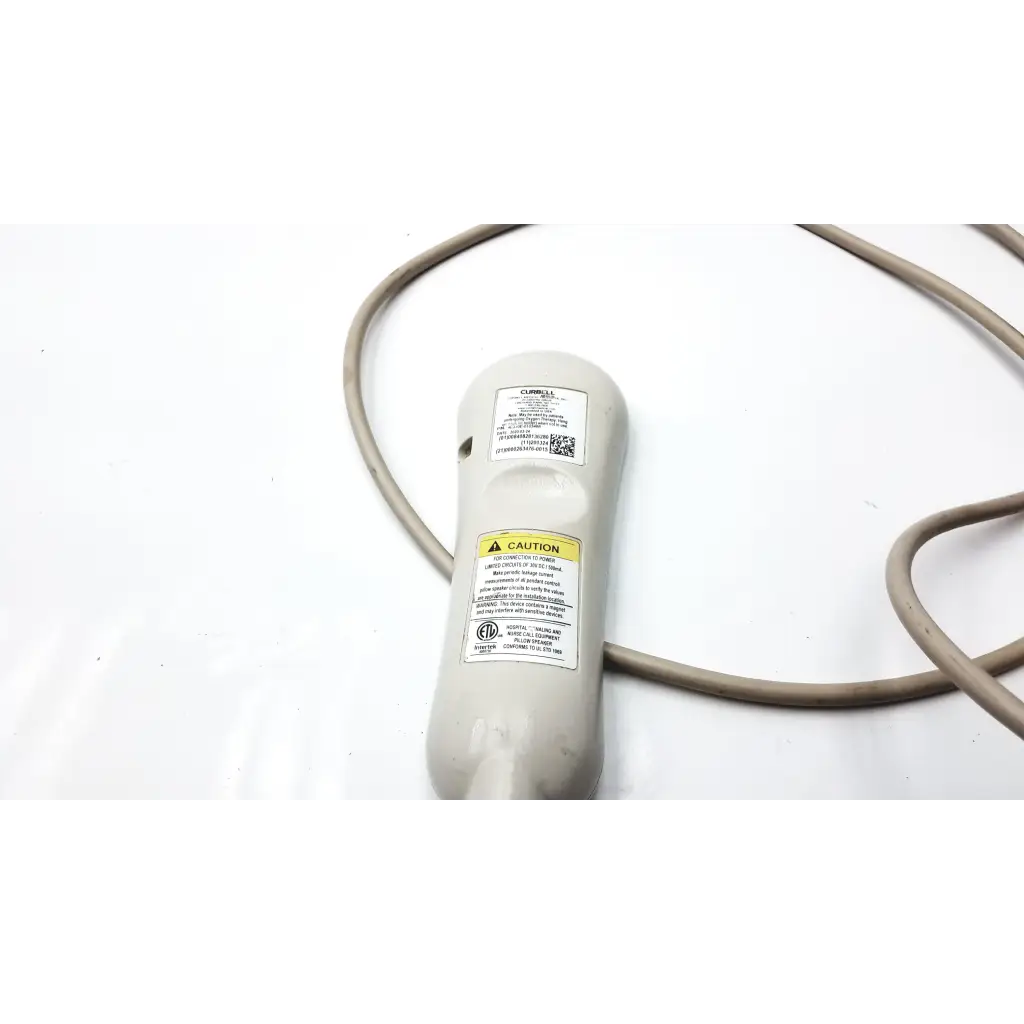 Gray plastic curbell speaker nurse call remote with coiled cable warning labels and certification stickers on back side