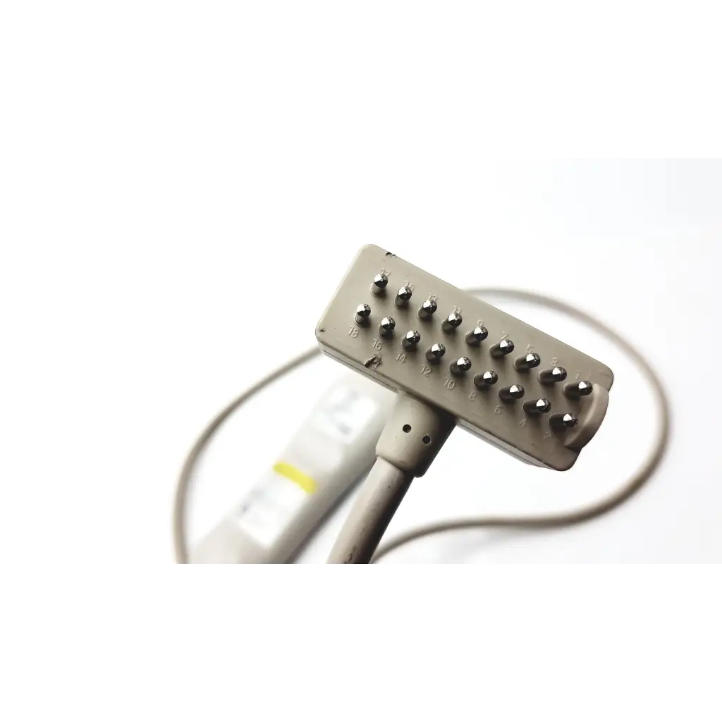Gray rectangular curbell speaker nurse call remote with metallic numbered protrusions for targeted muscle stimulation