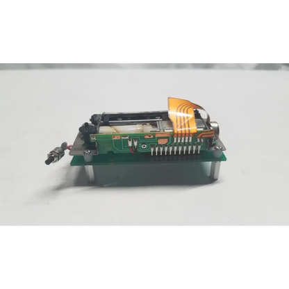 Green data synceng circuit board with orange flexible ribbon cable and metallic components featuring PIC16F628A chip