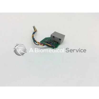 Gray rectangular sensor module mounted on green datex ohmeda board bbcc1-6 with multicolored wires extending
