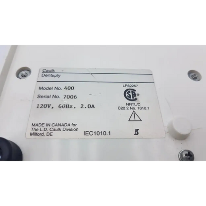 White rectangular label with black text on densply promix 400 dental amalgamator mixing system electrical device back side