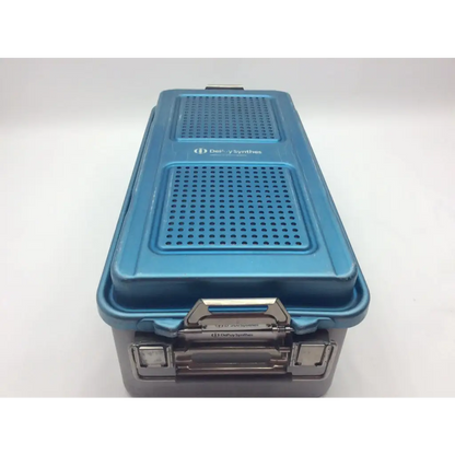 Blue DePuy Synthes two level solid sterilization container with perforated lid and metallic latch for surgical use