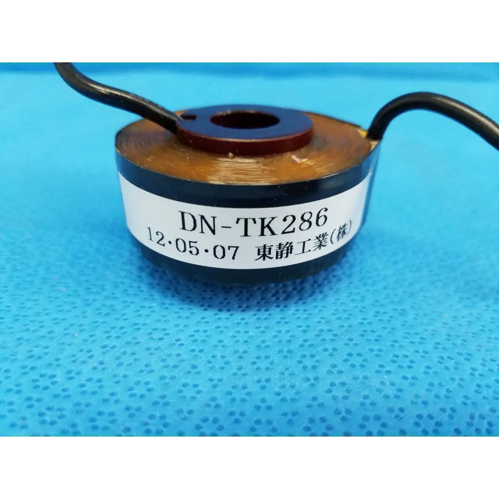 Dn-tk286 cylindrical copper-wound toroidal current transformer sensor coil with black wire leads and a white label