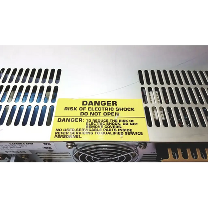 Yellow warning label on the back of electronic measurements ems power supply cautioning against electric shock risk