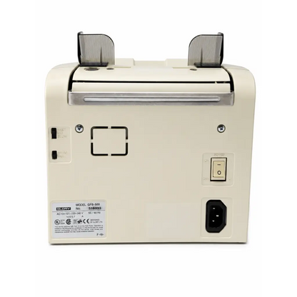 Cream-colored glory qfb-500 currency counting machine back with silver accents and power switch shown with dual battery charger
