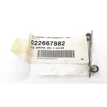 Metallic lid spring two pieces packaged in clear plastic with white label from drinmann instruments inc for 5415r da23=27