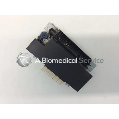 Black rectangular epson m-180 mini printer mechanism with metallic and blue gears and gold-colored printer mechanism needle pins