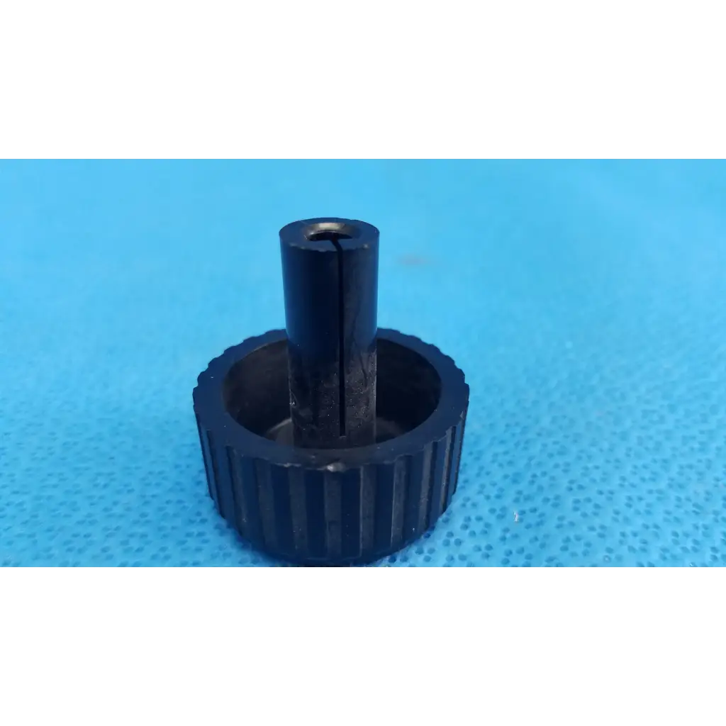 Black plastic ribbed knob with central shaft for external control panel dial adjustment on Topcon TRC-NW6S camera