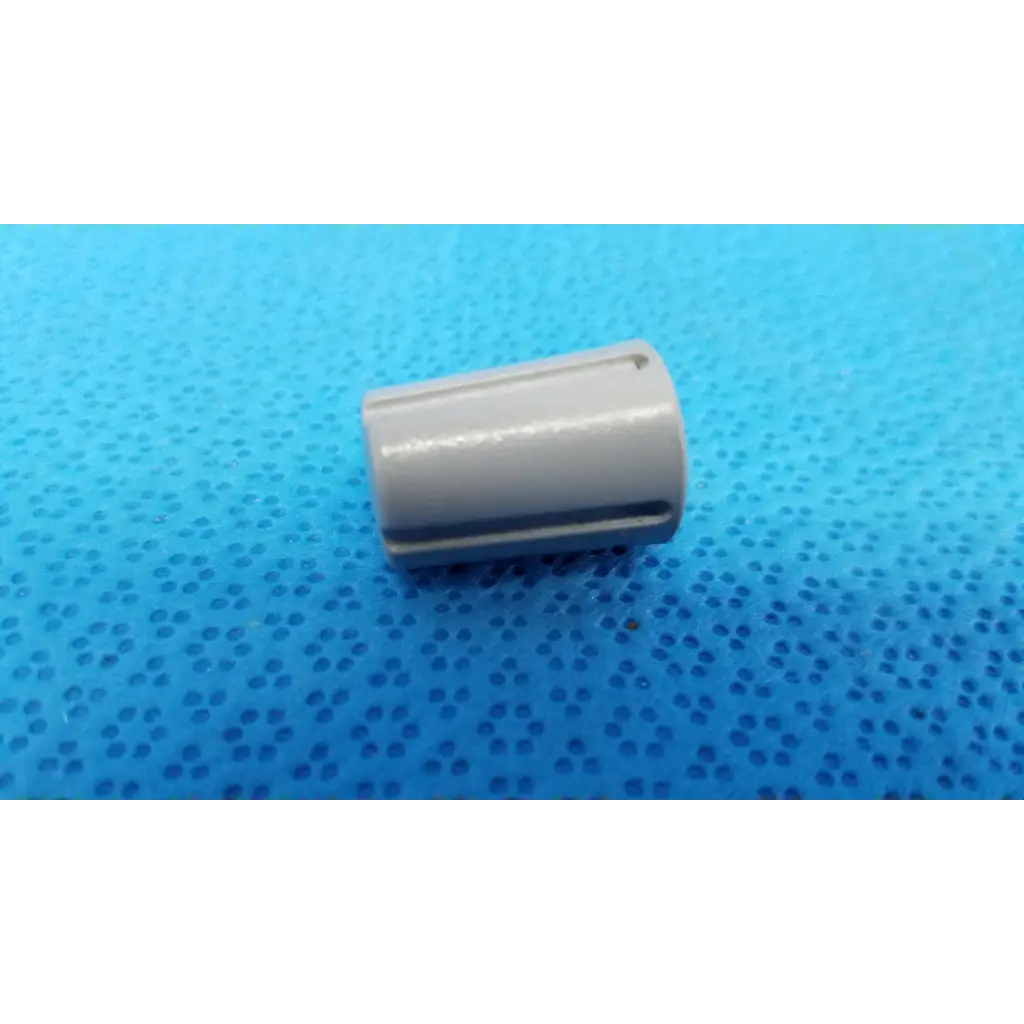 Gray cylindrical capacitor with grooves and smooth finish for external control panel rotary dial adjustment knob with indicator stripe