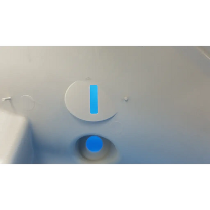 White circular button with blue vertical stripe and glowing blue circle on main optical body left side shroud housing panel