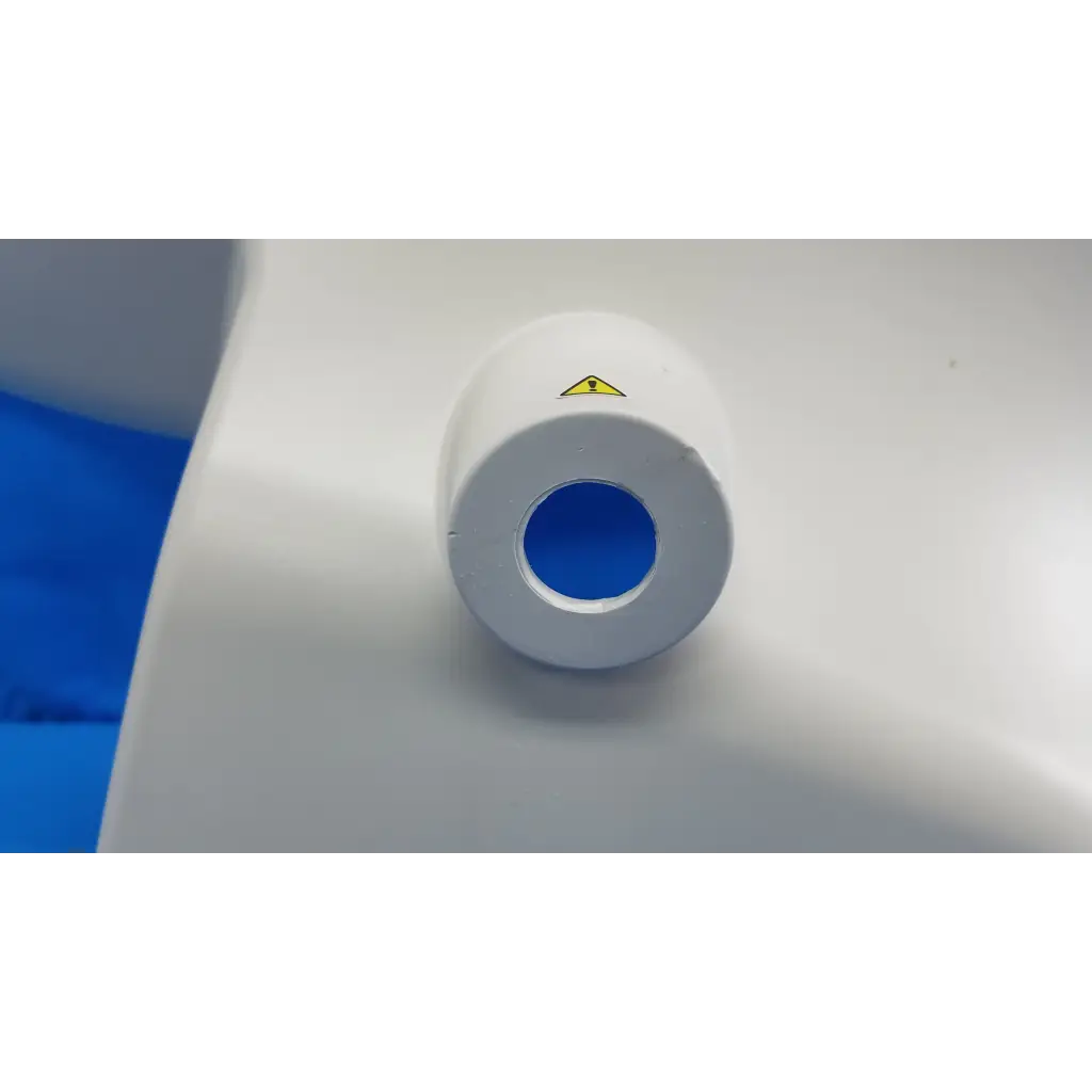 White cylindrical external main optical body side shroud housing cover panel with blue interior and yellow warning label for Topcon fundus camera