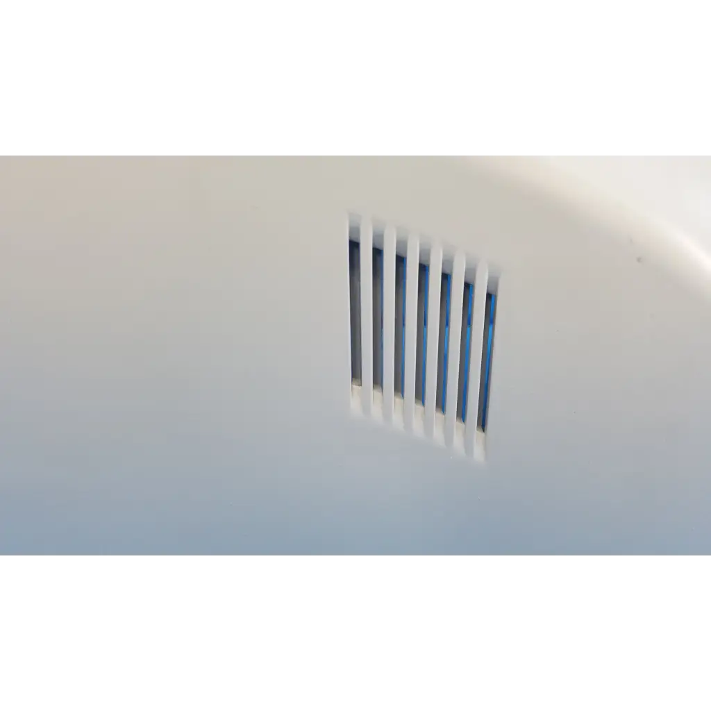 White plastic vent with vertical slats and blue interior on external main optical body side shroud housing cover panel