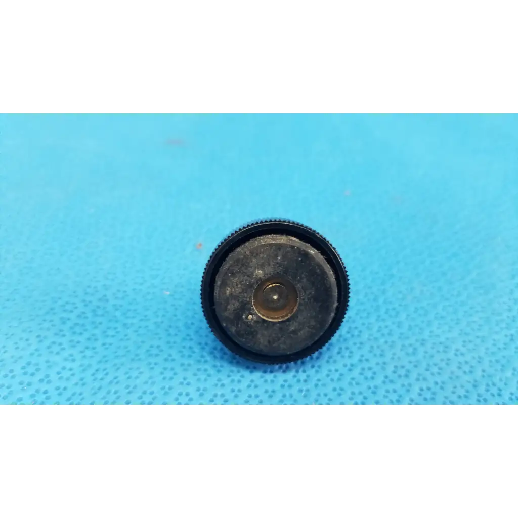 Black rubberized mechanical leveling screw foot with textured edge and central metallic ring for threaded bolt use