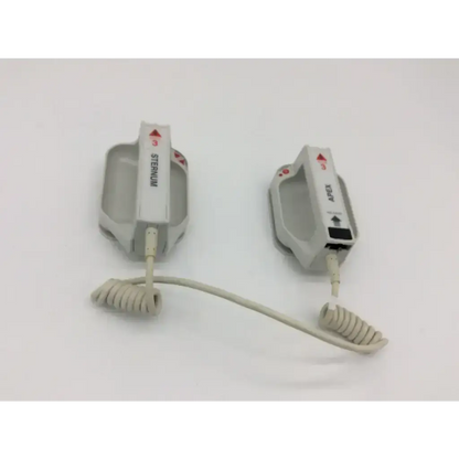 Two white external paddle assembly defibrillator pads with coiled cables labeled sternum and axis for medical emergency use
