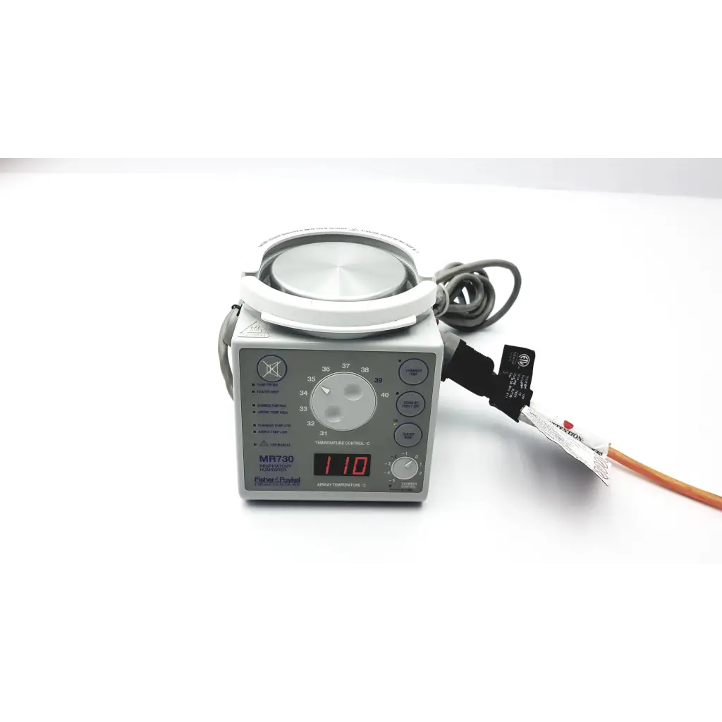 Fisher & Paykel humidifier MR730 with gray medical device, circular white heating pad, and digital display showing 110