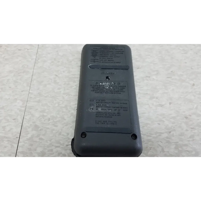 Gray plastic fluke 87 true rms digital handheld multimeter with black labeling and a small circular hole near the top