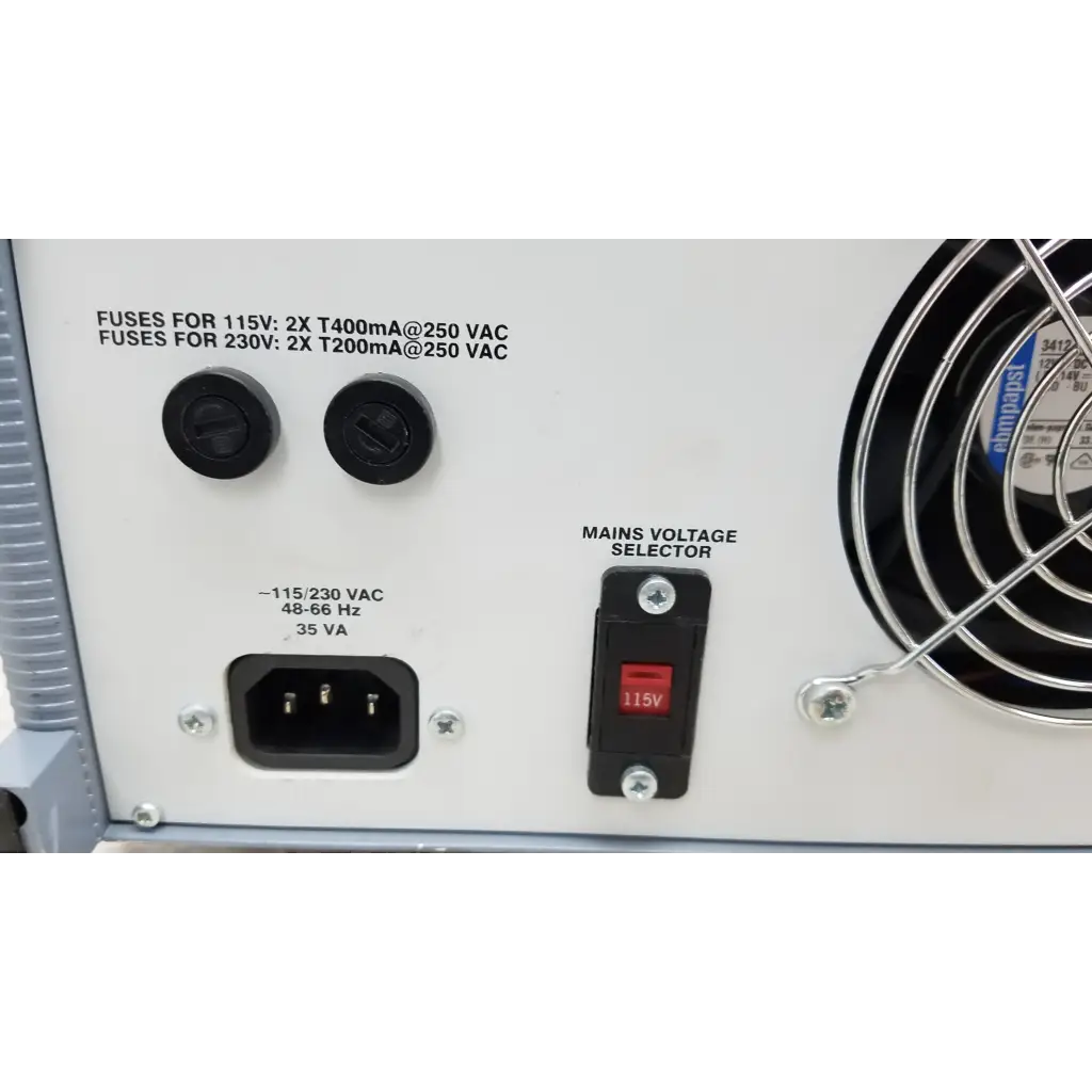 White power supply unit with black circular fuses red voltage selector and cooling fan on right side of fluke biomedical qa-esii electrosurgery analyzer