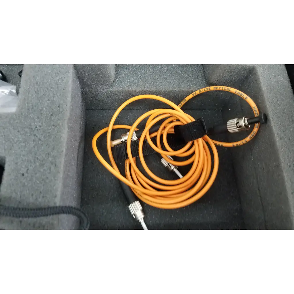 Orange fiber optic cable with metallic connectors and black strap included with fluke networks fos 850/1300 fiber optic source