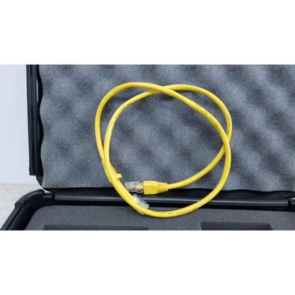 Yellow ethernet cable with clear rj45 connectors coiled in black foam-lined case for fluke networks fiber optic source