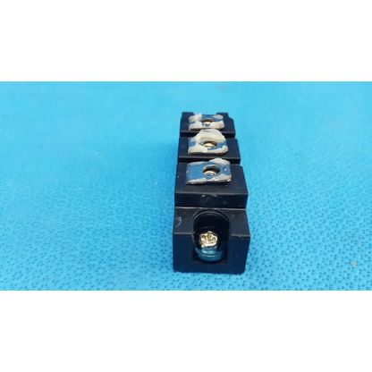 Black plastic electrical terminal block with four slots and screws on fuji electric dual diode power diode module